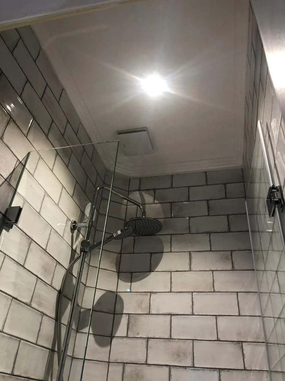 Nachher: Duschbereich mit Metrofliesen und Regendusche