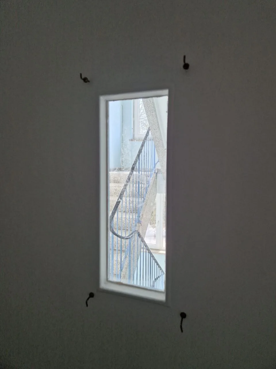 Innenwand mit Fenster zum Treppenhaus in renoviertem Gebäude