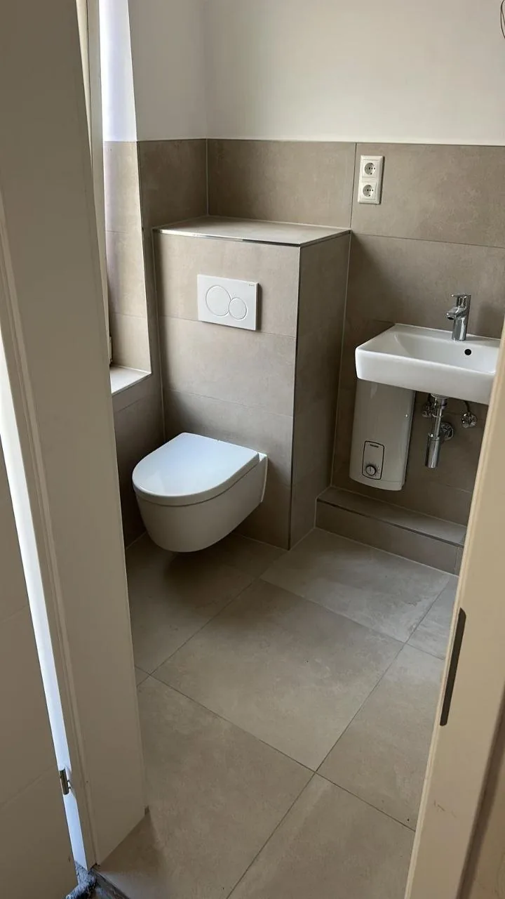 Nachher: Bad mit WC und grauen Fliesen