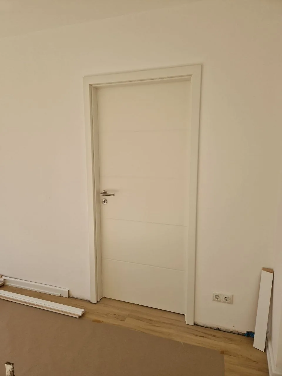Weiße Innentür mit sauber gefasster Zarge in renoviertem Wohnraum