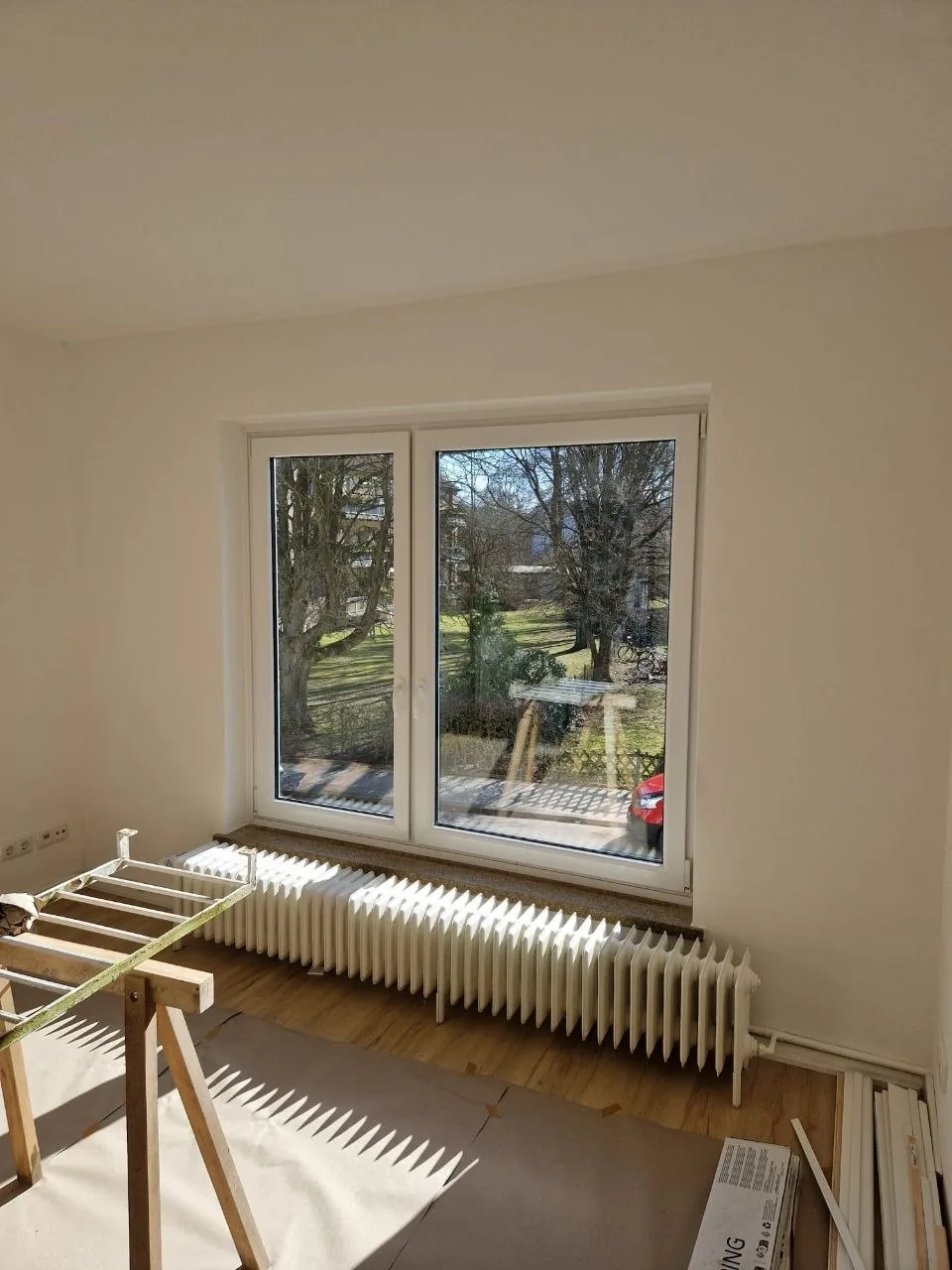 Abgedeckter Heizkörper und vorbereitete Flächen im Wohnraum