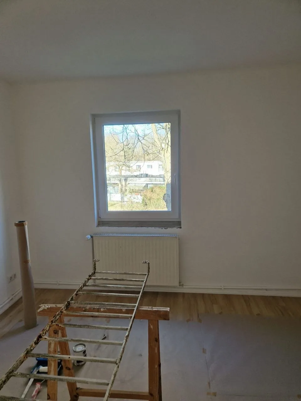 Zimmer in Renovierung mit Arbeitsbock, Fenster und Heizkörper